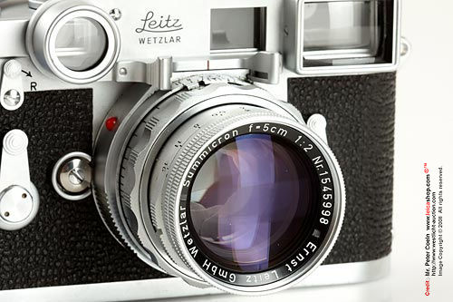 Close view of a Summicron f=5cm 1:2 lens with close focus attachment unit on a 1958 double stroke Leica M3 rangefinder (RF) camera model